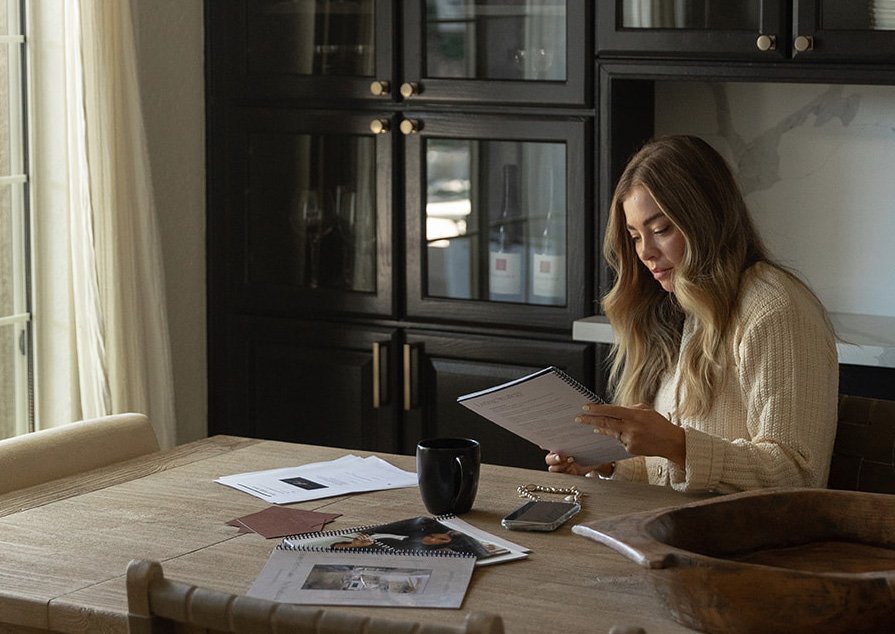 BryAnn Buhl reviewing property materials at a kitchen table